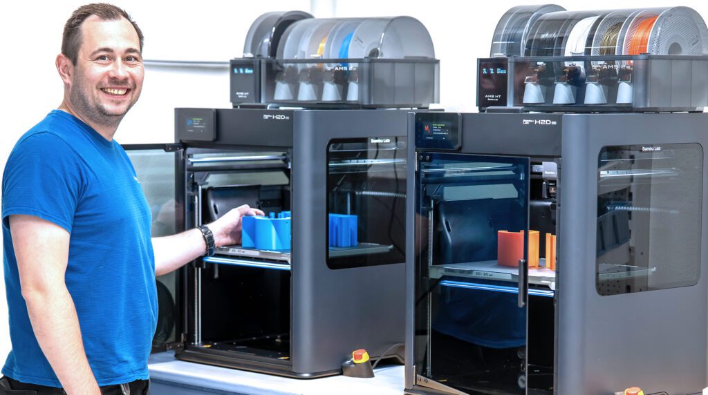 miunske Mitarbeiter aus der Konstruktion am 3D Drucker
